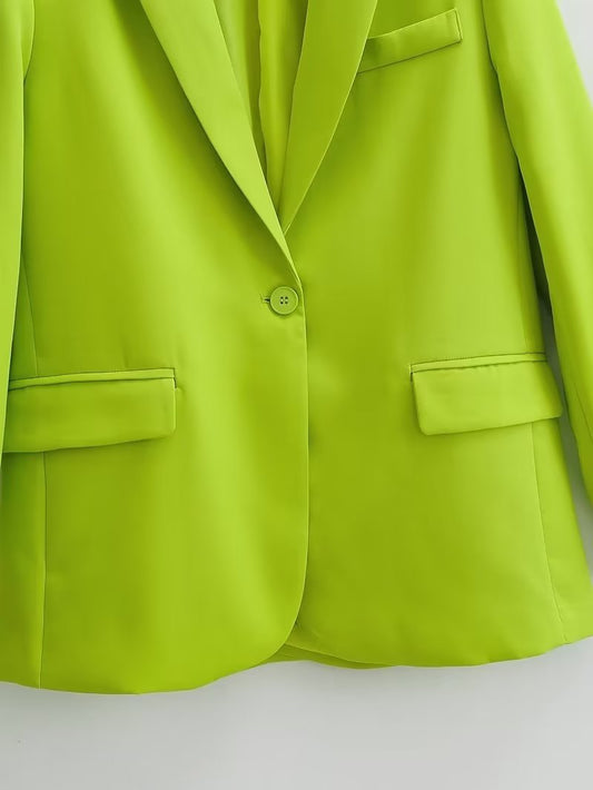 Le donne che fanno il pendolare indossano blazer con taschino verde fluorescente e un bottone